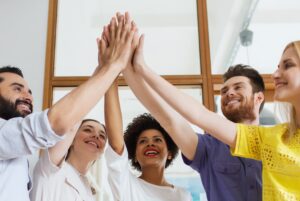 group of people high fiving in workplace