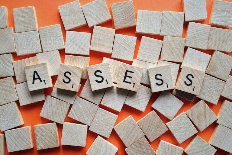 scrabble letters spelling out ASSESS
